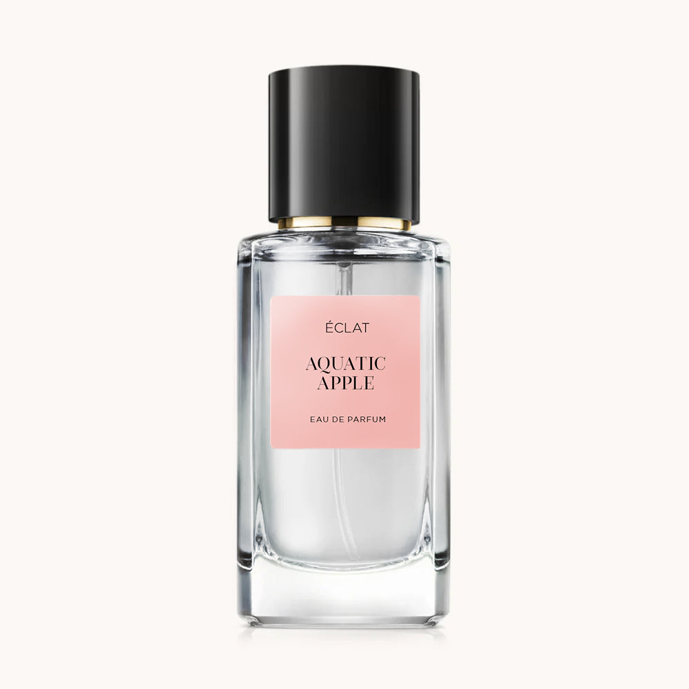 Flacon of the women’s perfume dupe ÉCLAT Aquatic Apple RAR, an elegant transparent glass bottle with a black cylindrical magnetic cap and a dark pink label. The label displays the brand name ÉCLAT, the name Aquatic Apple RAR, and the phrase “Eau de Parfum”.