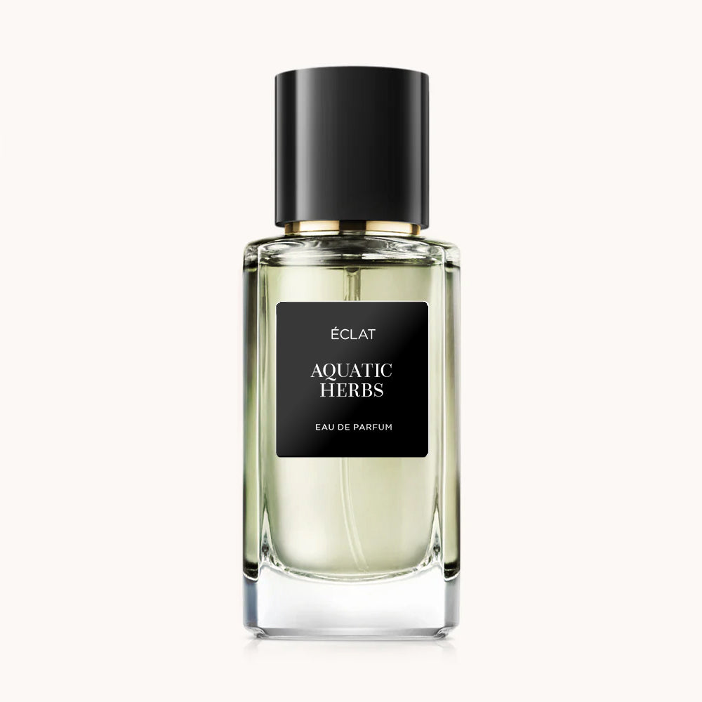 Flacon of the men's perfume dupe ÉCLAT Aquatic Herbs, an elegant transparent glass bottle with a black cylindrical magnetic cap and a black label. The label displays the brand name ÉCLAT, the name Aquatic Herbs, and the phrase “Eau de Parfum”.