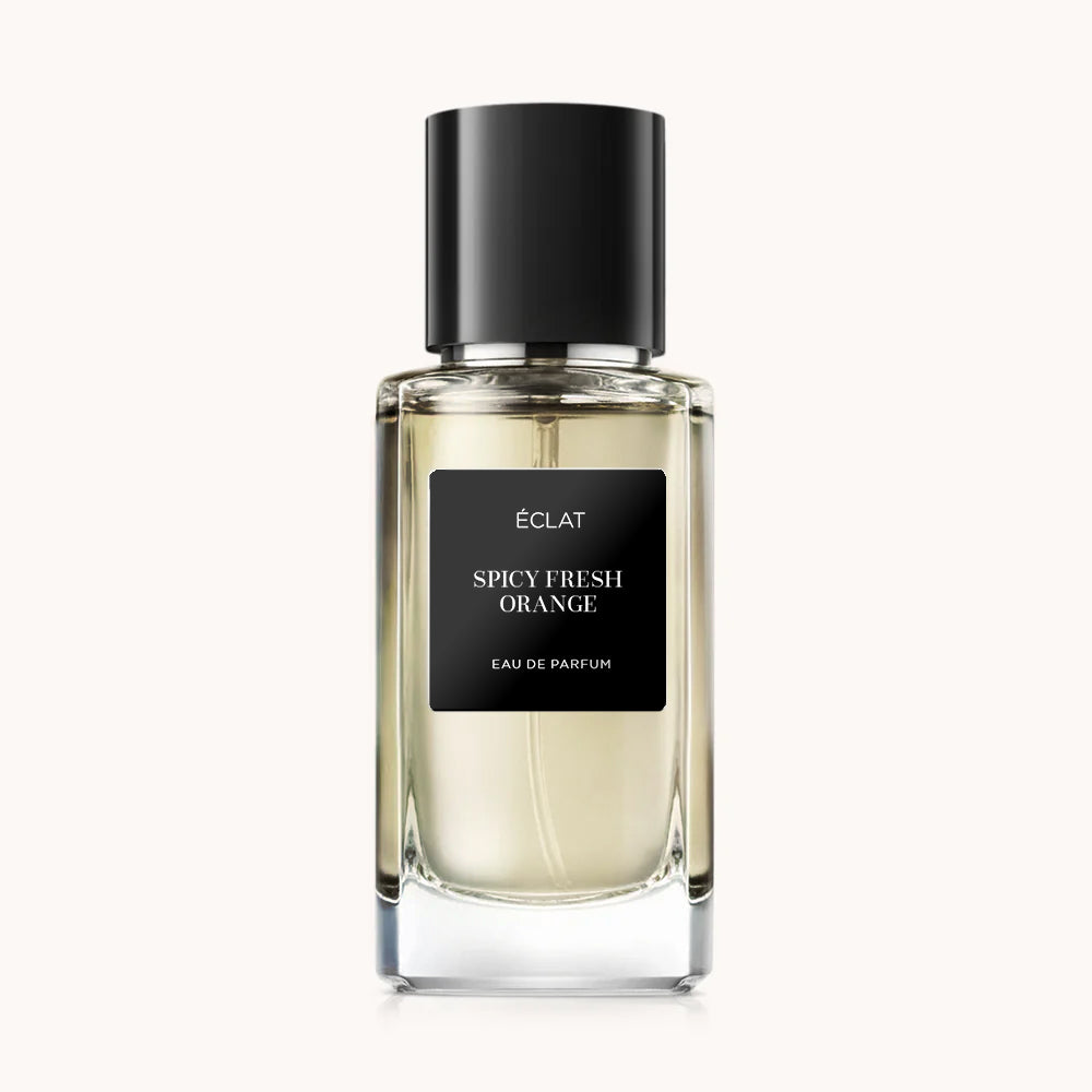 Flacon of the men's perfume dupe ÉCLAT Spicy Fresh Orange, an elegant transparent glass bottle with a black cylindrical magnetic cap and a black label. The label displays the brand name ÉCLAT, the name Spicy Fresh Orange, and the phrase “Eau de Parfum”.