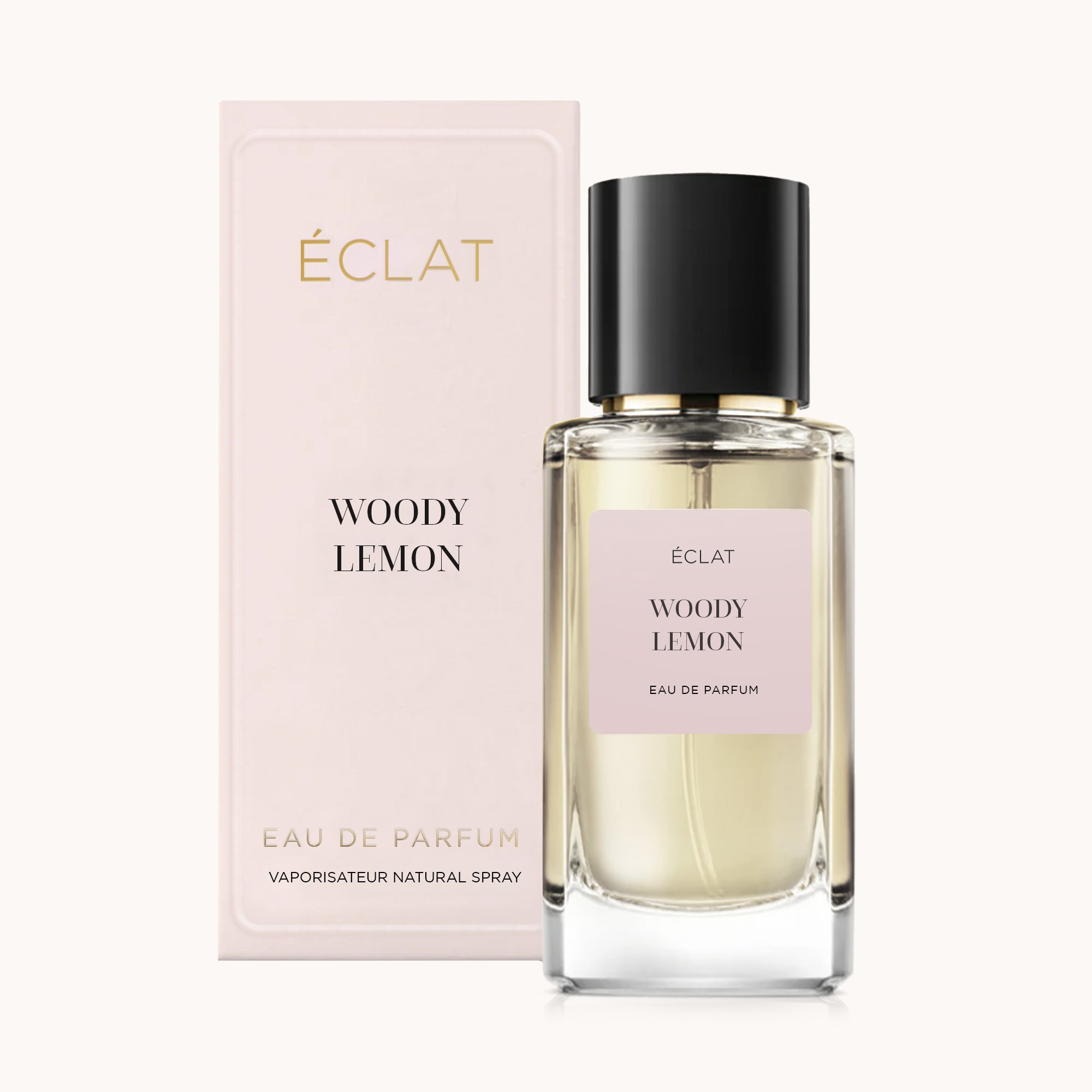 Fasetowana szklana butelka ÉCLAT Woody Lemon z czarną nakrętką, obok bladoróżowego pudełka z tą samą nazwą.