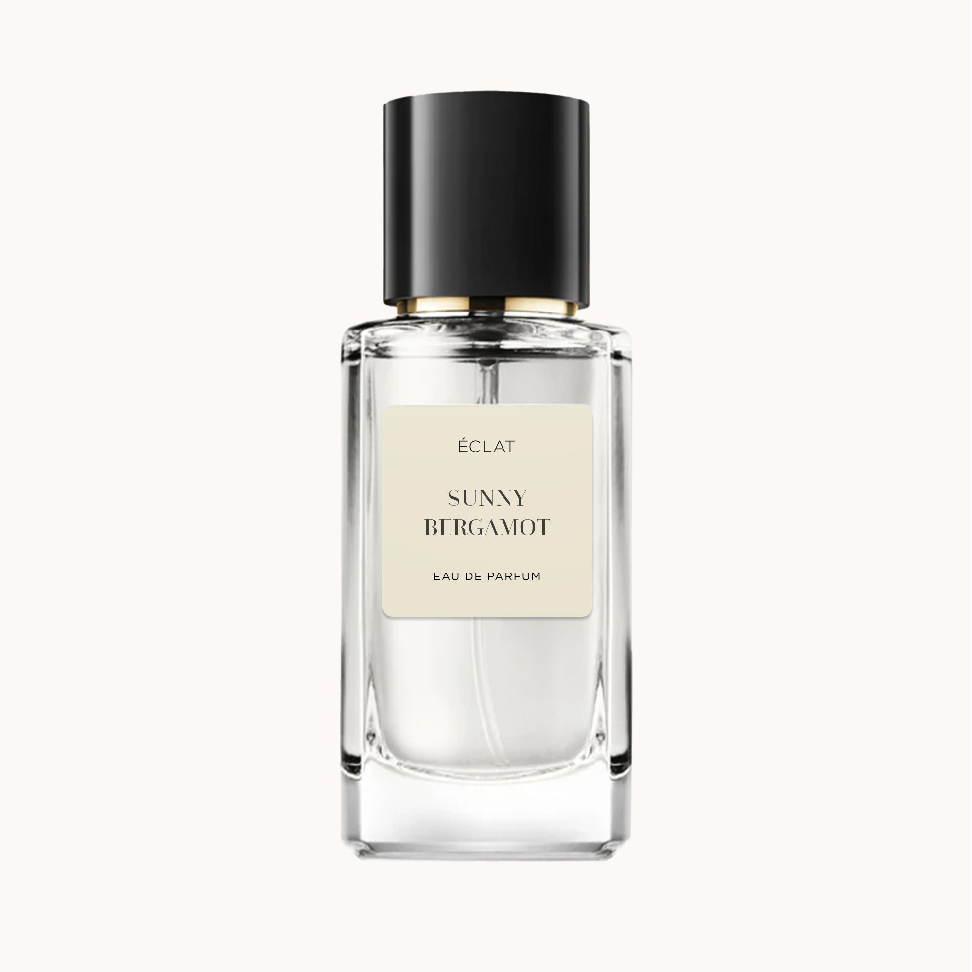 Fasetowana szklana butelka ÉCLAT Sunny Bergamot z czarną nakrętką i kremową etykietą.