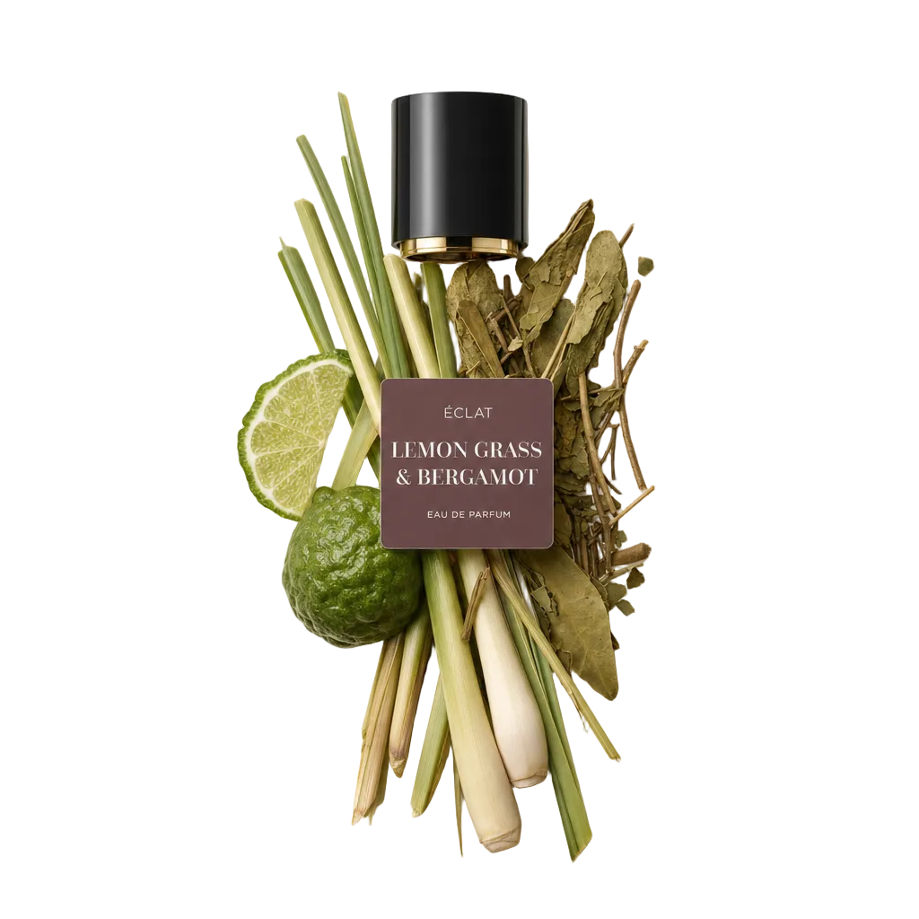 Aranżacja z łodygi trawy cytrynowej, liści kaffir lime, plasterków limonki i całego owocu bergamotki, obok czarnej nakrętki z etykietą ÉCLAT Lemon Grass & Bergamot.