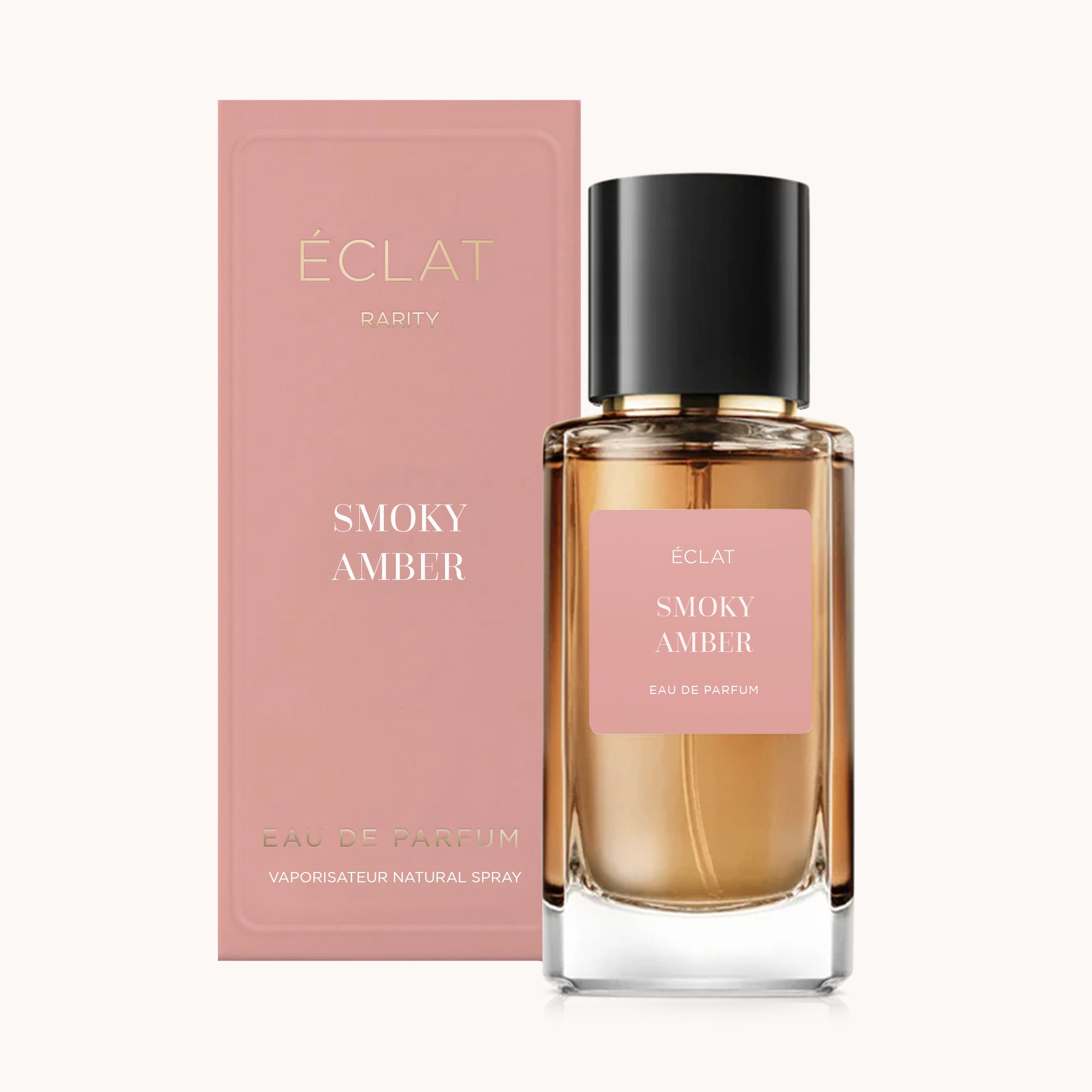 Flakon perfum ÉCLAT Smoky Amber z różową etykietą i czarną nakrętką, w towarzystwie pasującego różowego pudełka.