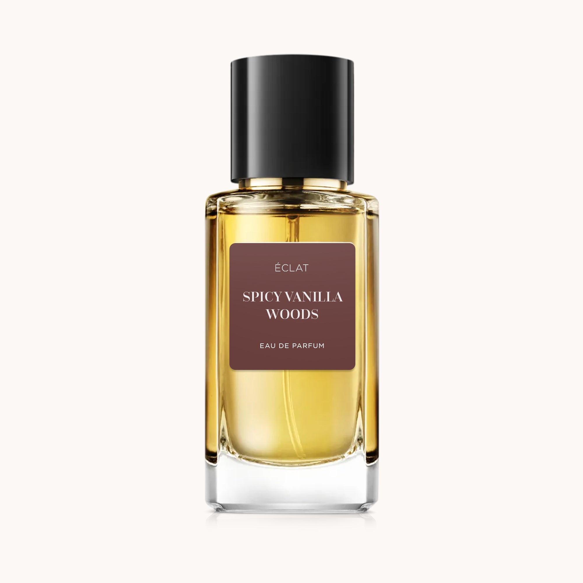 ÉCLAT Spicy Vanilla Woods w przezroczystej szklanej butelce z czarną zakrętką i brązową etykietą.