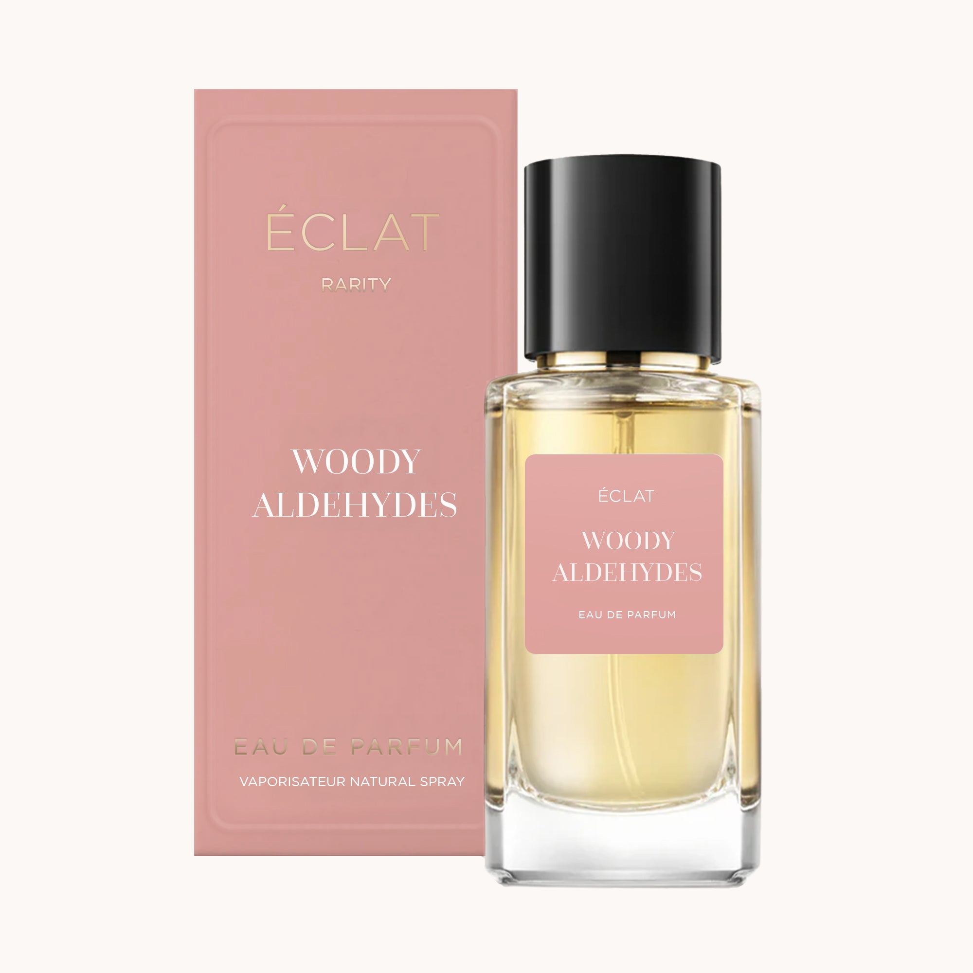 ÉCLAT Woody Aldehydes w fasetowanej szklanej butelce z czarną nakrętką, w towarzystwie różowego pudełka.