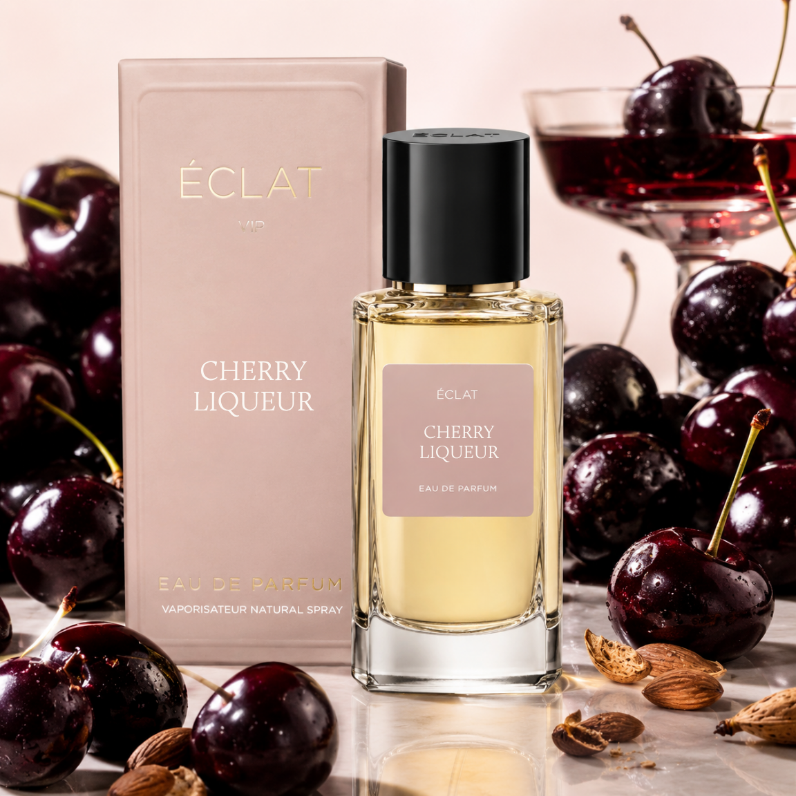 Obraz przedstawia perfumy ÉCLAT Cherry Liqueur z fasetowaną szklaną butelką i czarną nakrętką, obok różowego pudełka i świeżych wiśni.