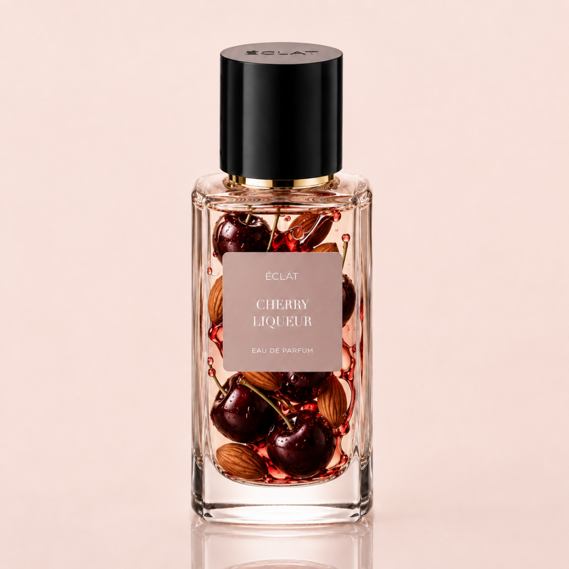 Fasetowana szklana butelka ÉCLAT Cherry Liqueur eau de parfum z czarnym korkiem i etykietą przedstawiającą wiśnie i migdały.
