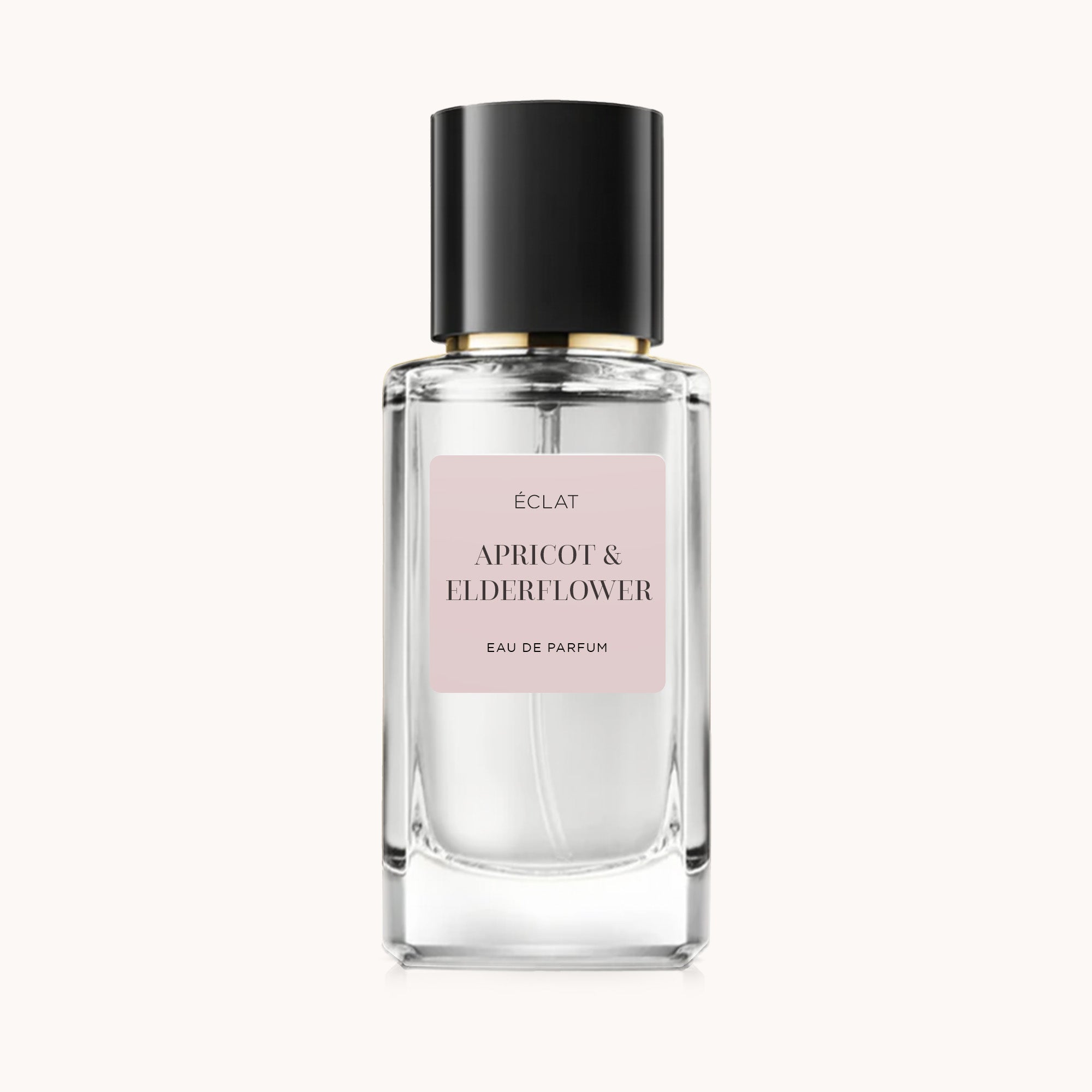 Fasetowana szklana butelka ÉCLAT Apricot & Elderflower z czarną nakrętką i delikatną różową etykietą.