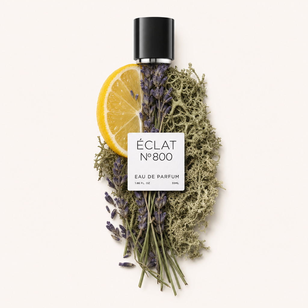 Kompozycja z plasterka cytryny, gałązek lawendy i mchu dębowego otacza oryginalną czarną nasadkę z etykietą ÉCLAT Aromatic Oak Moss.