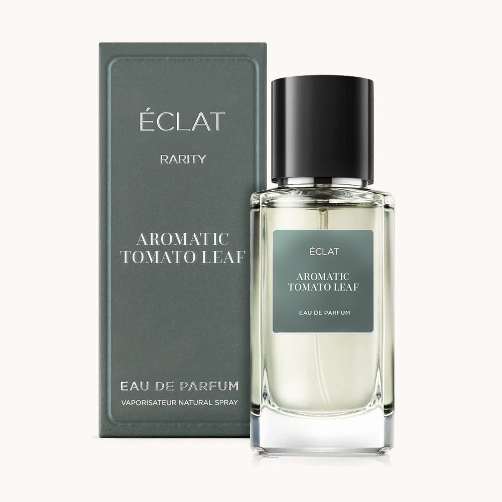 Flakon perfum ÉCLAT Aromatic Tomato Leaf z ciemnozieloną etykietą i czarną nakrętką, obok pasującego pudełka.