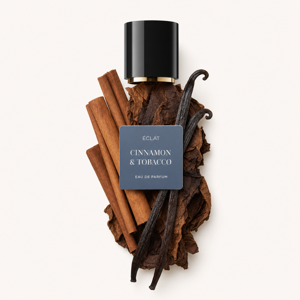 Kompozycja z lasek cynamonu, liści tytoniu i strąków wanilii otacza czarną nakrętkę z etykietą ÉCLAT Cinnamon & Tobacco.