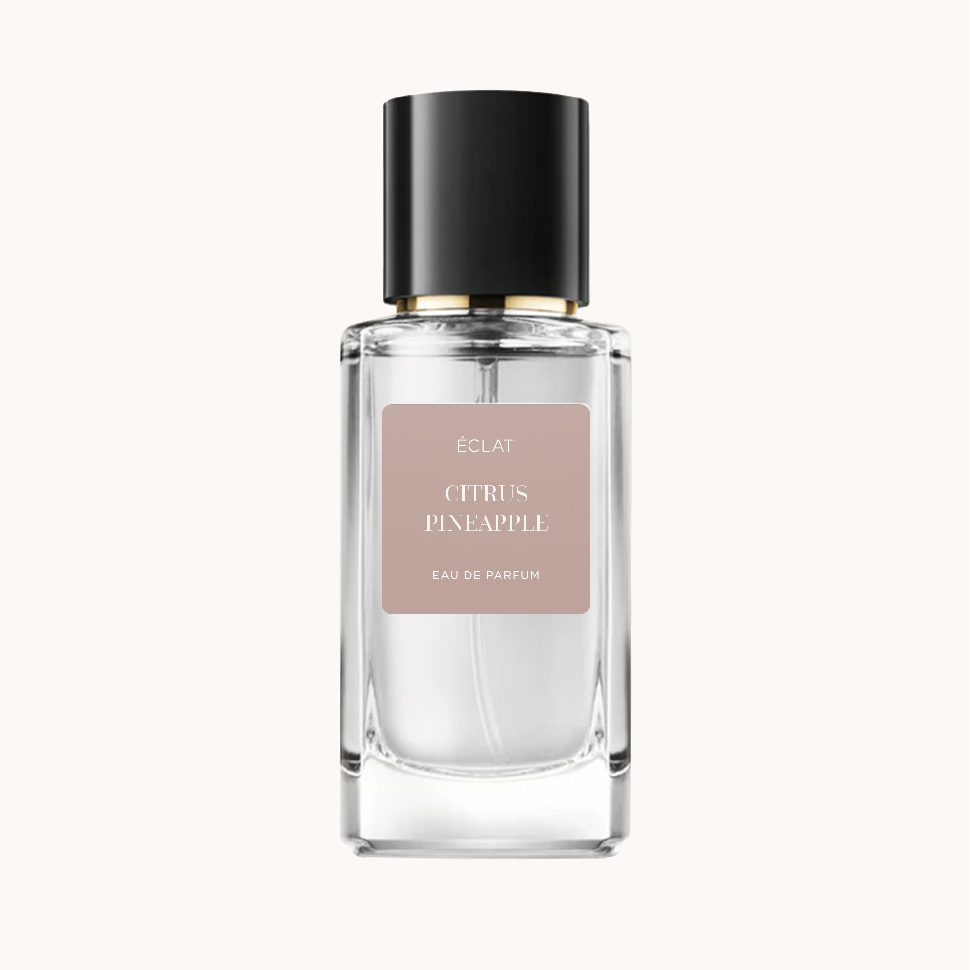 Fasetowana szklana butelka z czarnym korkiem zawiera ÉCLAT Citrus Pineapple Eau de Parfum. Etykieta ma delikatny beżowy odcień.
