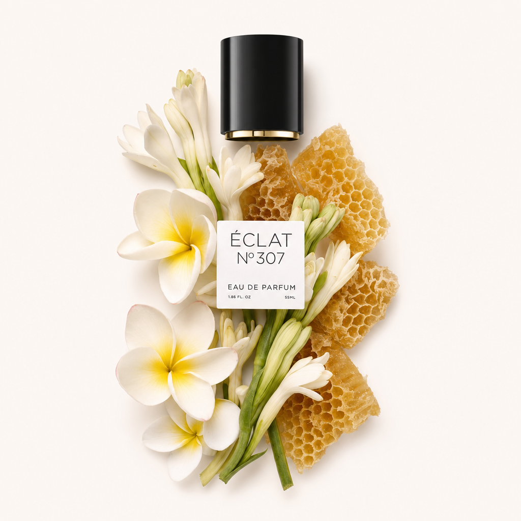Kompozycja z białych kwiatów i plastra miodu wokół czarnej nakrętki z etykietą ÉCLAT Floral Beeswax.