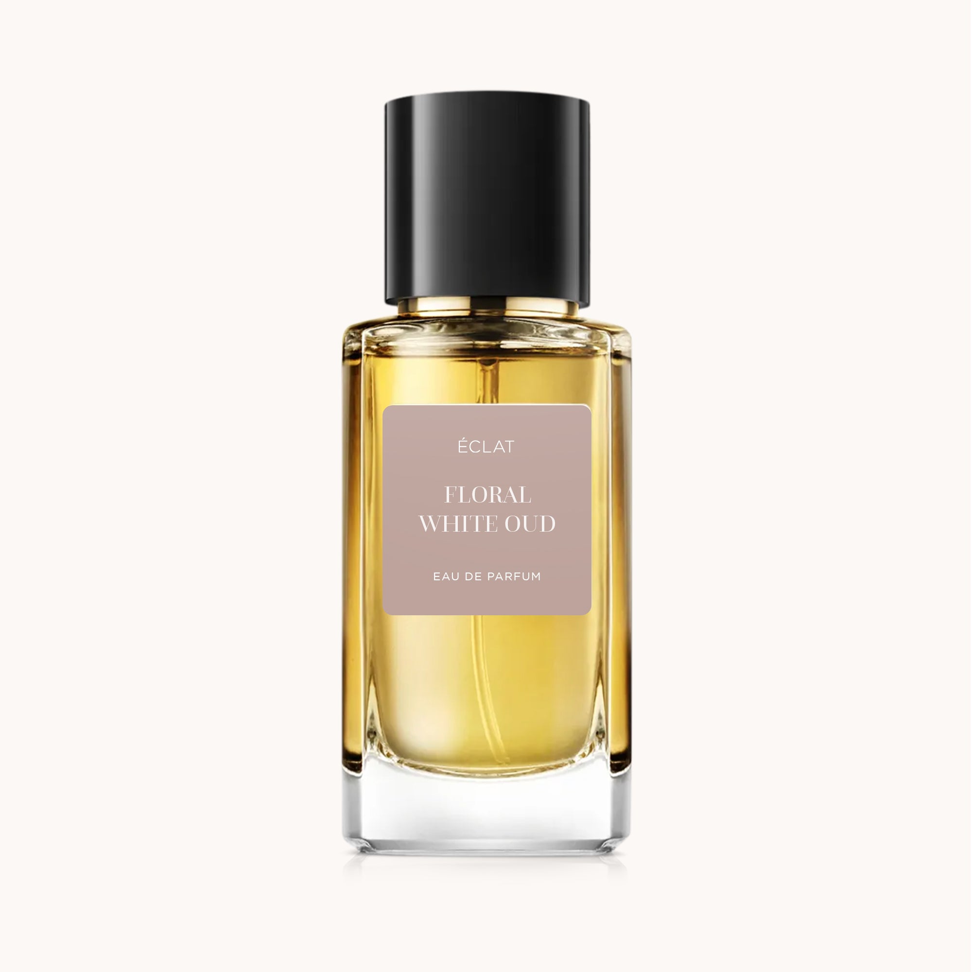 Perfumy ÉCLAT Floral White Oud prezentują szklany flakon o fasetowanej formie z czarną nakrętką i matową etykietą z nazwą.