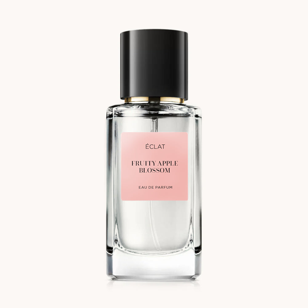 Perfumy ÉCLAT Fruity Apple Blossom w fasetowanej szklanej butelce z czarną nakrętką i różową etykietą.