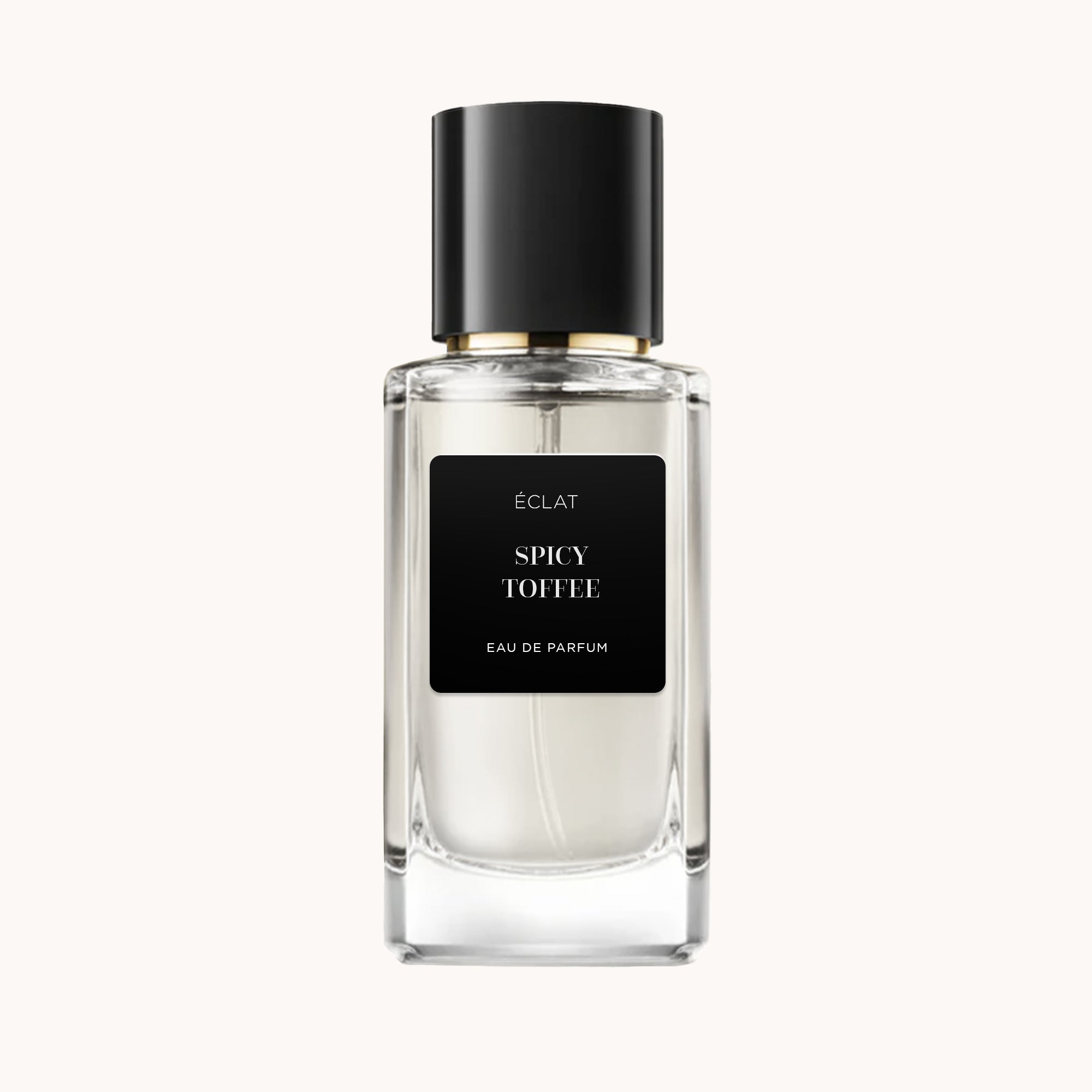 Perfum ÉCLAT Spicy Toffee ma przezroczystą, fasetowaną szklaną butelkę z matową czarną etykietą i elegancką czarną nakrętką.
