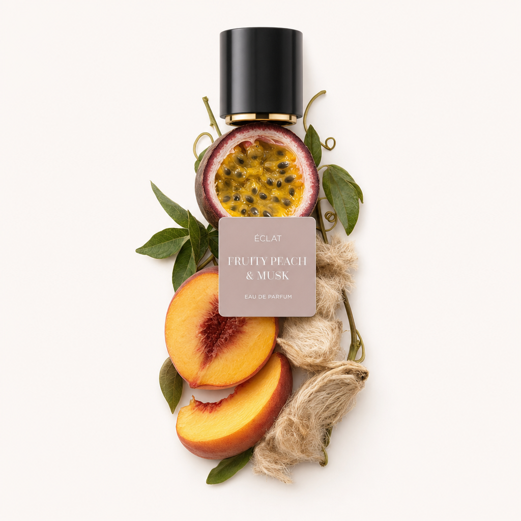 Aranżacja świeżych plastrów brzoskwini, owocu pasji i nasion piżma z zielonymi liśćmi, pod czarną nakrętką z etykietą ÉCLAT Fruity Peach & Musk.