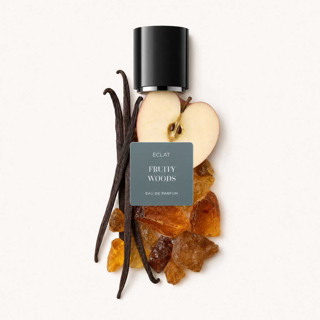 Kompozycja z plastra jabłka, strąków wanilii i żywic, zwieńczona czarną nakrętką z etykietą ÉCLAT Fruity Woods.