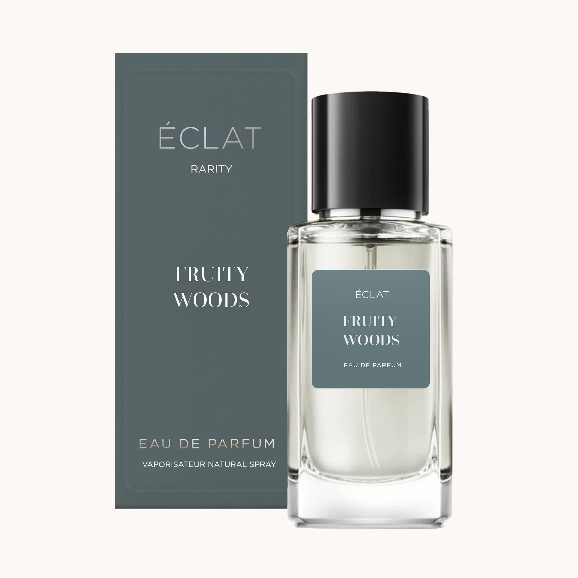 Butelka perfum ÉCLAT Fruity Woods obok eleganckiego ciemnozielonego opakowania.