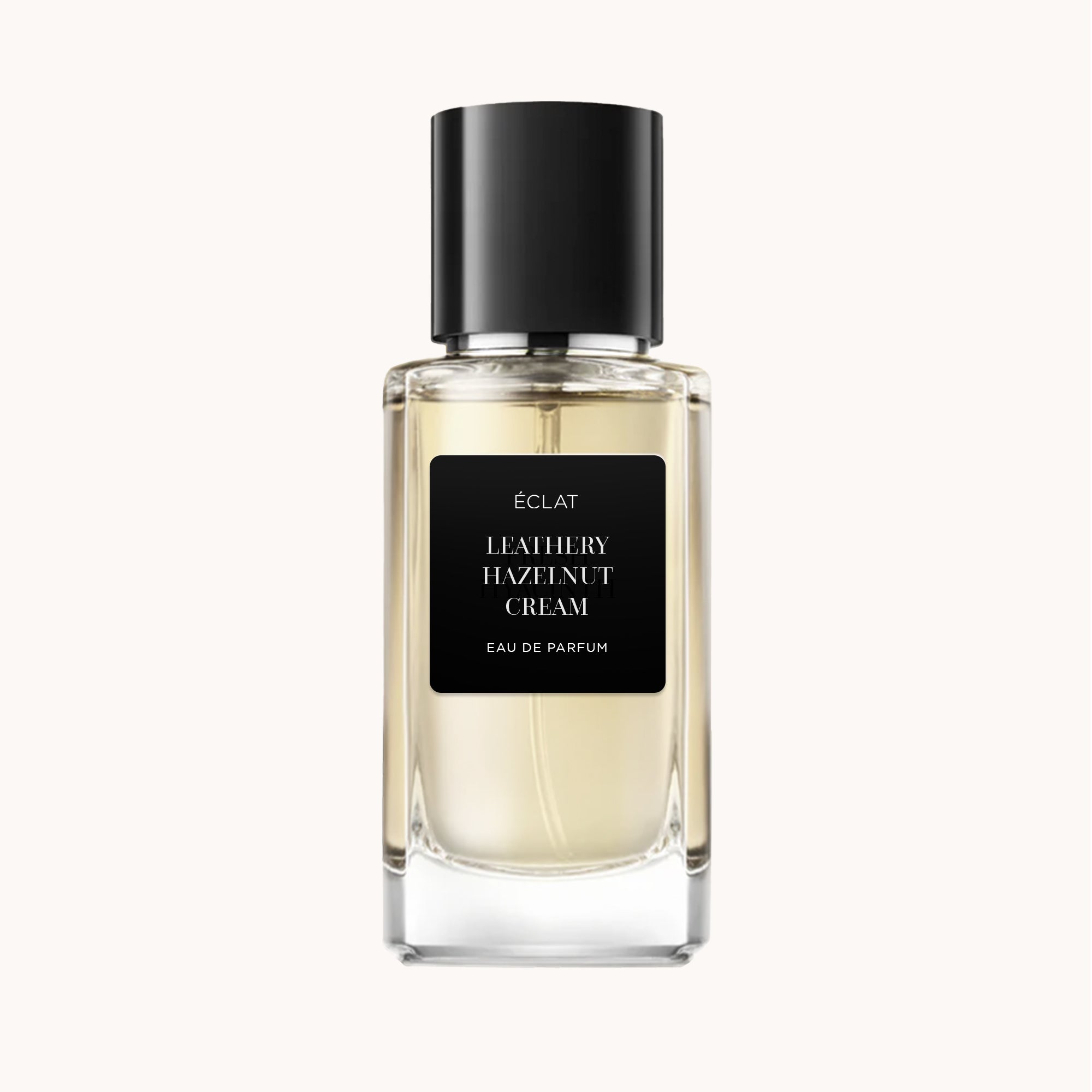 Wyrafinowany fasetowany flakon ÉCLAT Leathery Hazelnut Cream z elegancką czarną nakrętką.