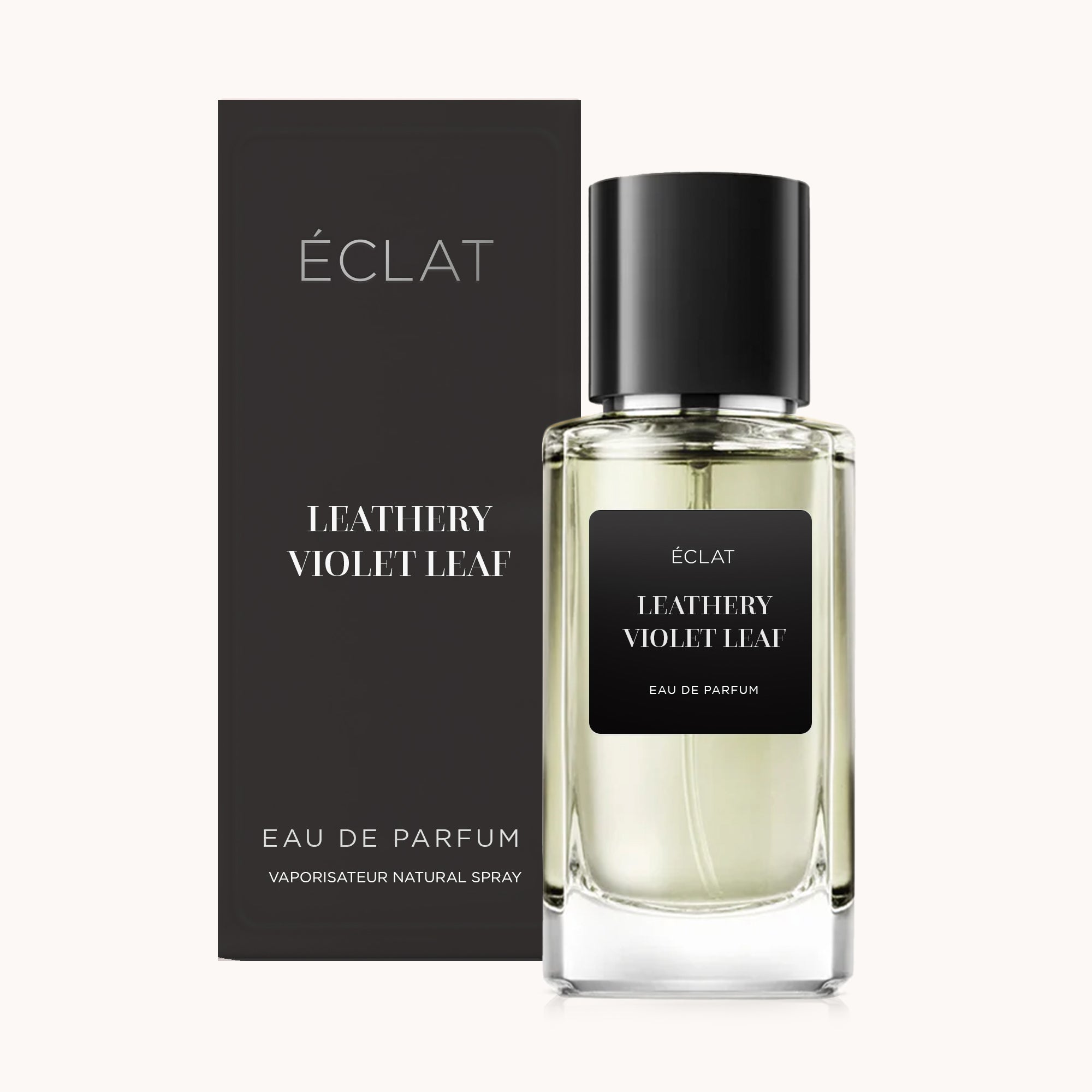 Perfum ÉCLAT Leathery Violet Leaf w przezroczystym szklanym flakonie z czarną etykietą i czarnym korkiem, w towarzystwie eleganckiego czarnego pudełka.