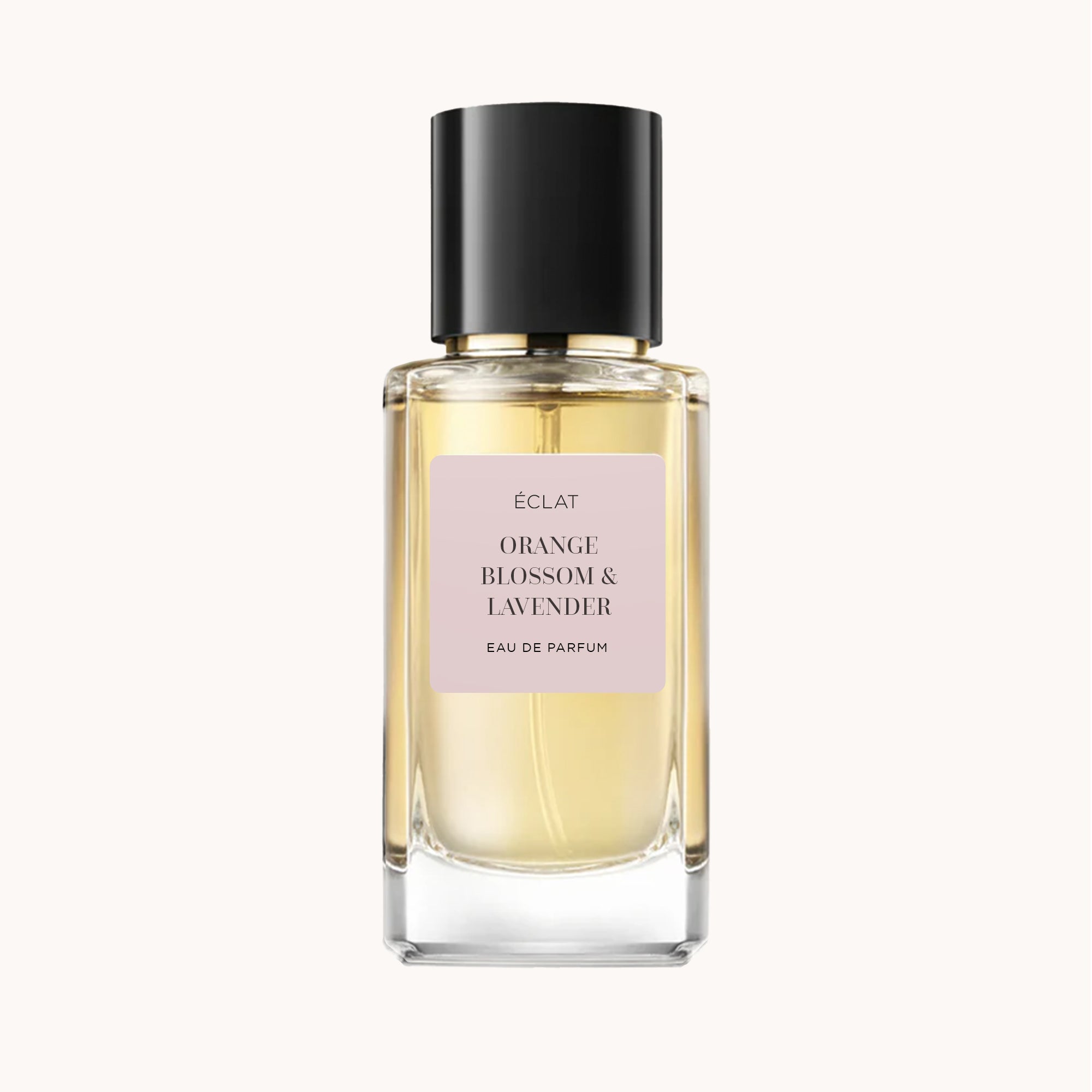 Fasetowana szklana butelka ÉCLAT Orange Blossom & Lavender z czarną nakrętką i delikatnie różową etykietą.