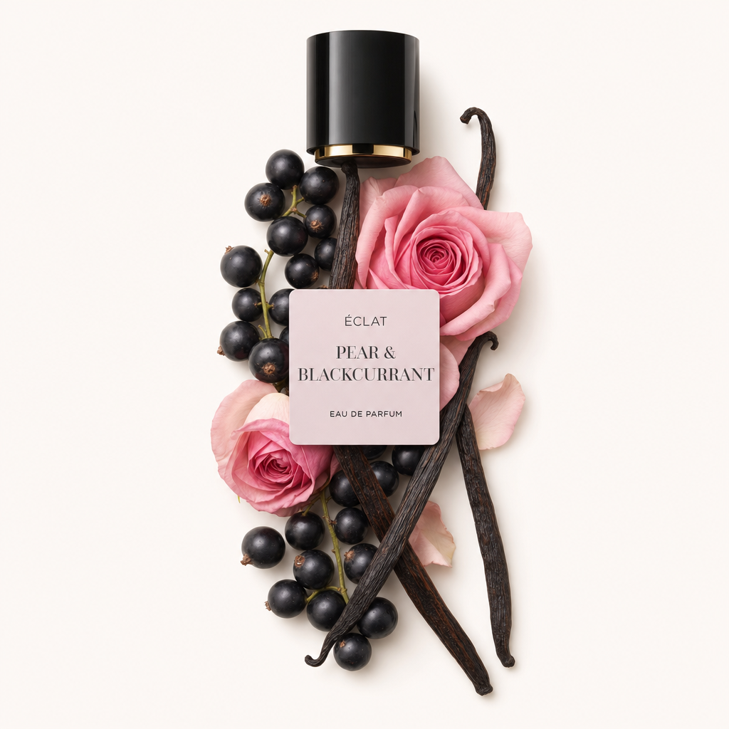 Kompozycja z czarnej porzeczki, różowych róż i lasek wanilii z czarną nasadką i etykietą z napisem ÉCLAT Pear & Blackcurrant.