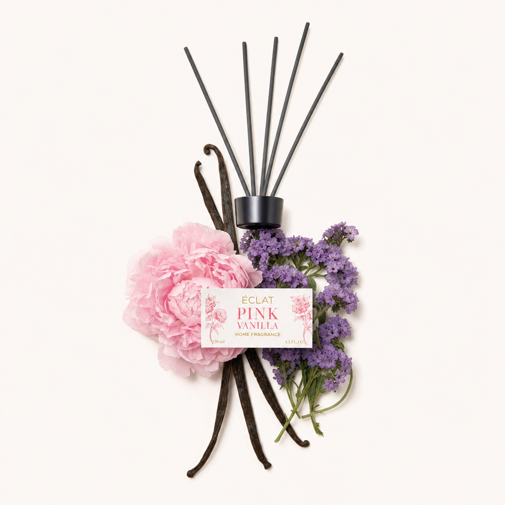 Aranżacja z różowych piwonii, strąków wanilii i gałązek lawendy, otaczająca czarną nakrętkę z etykietą ÉCLAT Pink Vanilla.