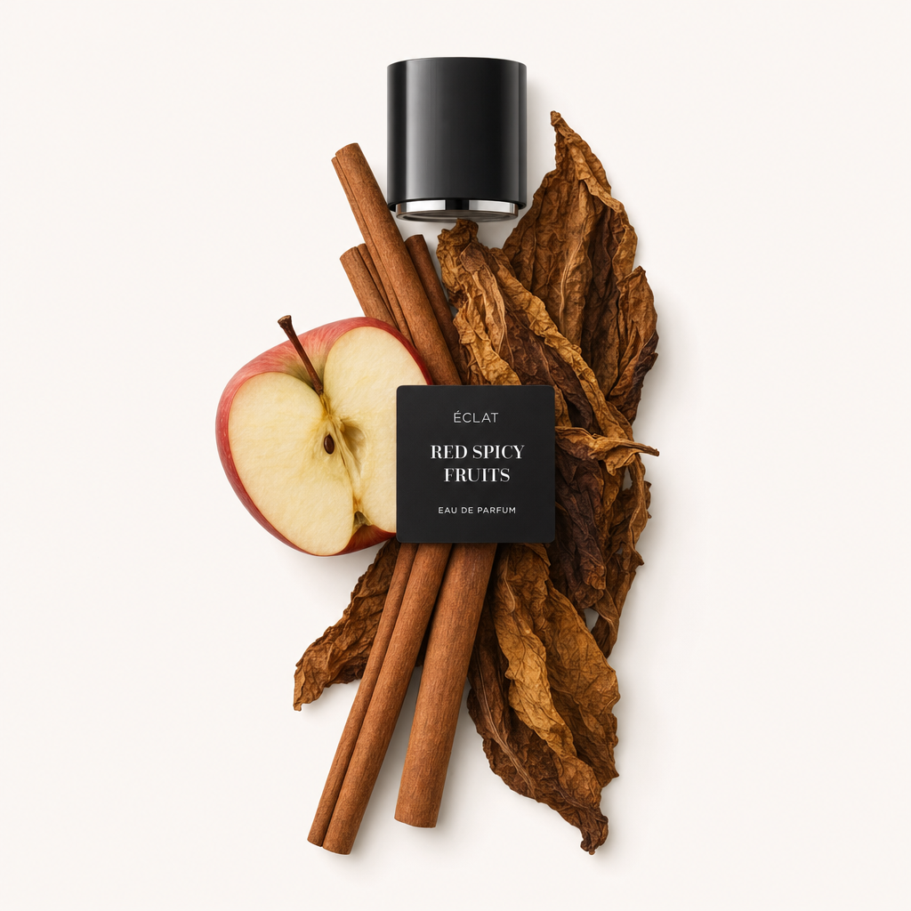 Kompozycja z lasek cynamonu, połowy czerwonego jabłka i dużych, suszonych liści tytoniu otacza czarną nakrętkę z etykietą ÉCLAT Red Spicy Fruits.