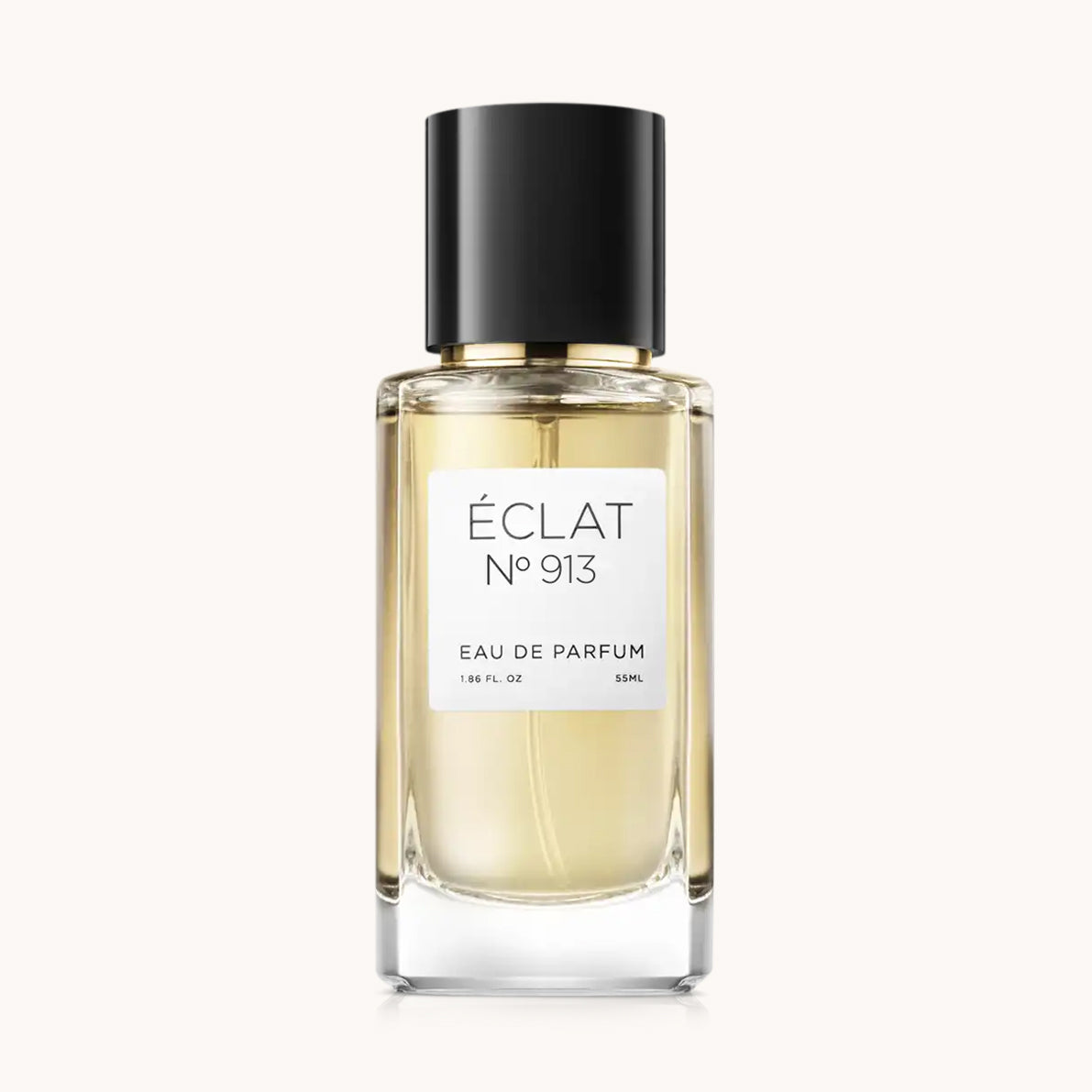 Perfumy ÉCLAT Spicy Caramel są w fasetowanej szklanej butelce z czarną zakrętką i elegancką białą etykietą.