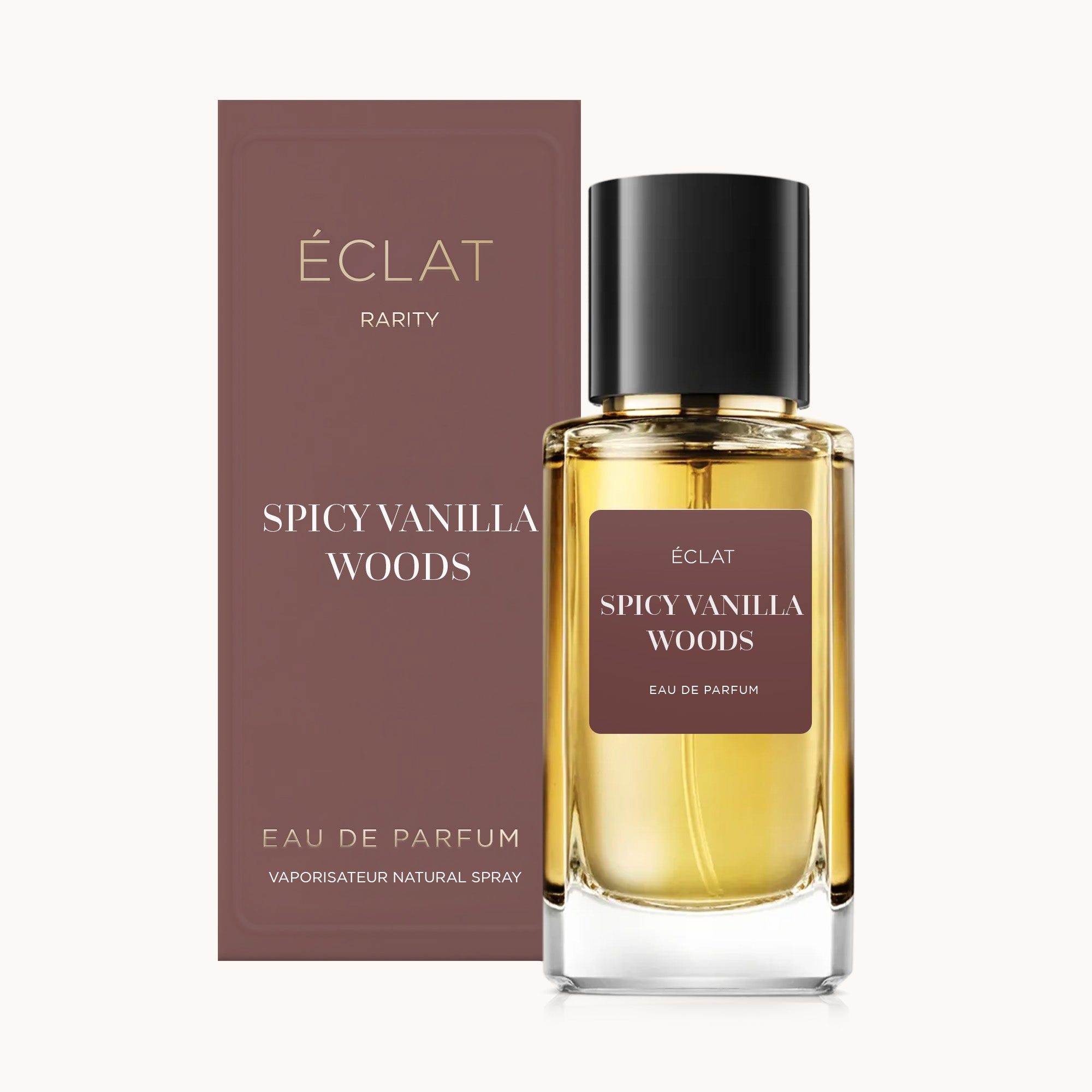 Fasetowana szklana butelka ÉCLAT Spicy Vanilla Woods z czarną nakrętką, obok pasującego kasztanowego pudełka.
