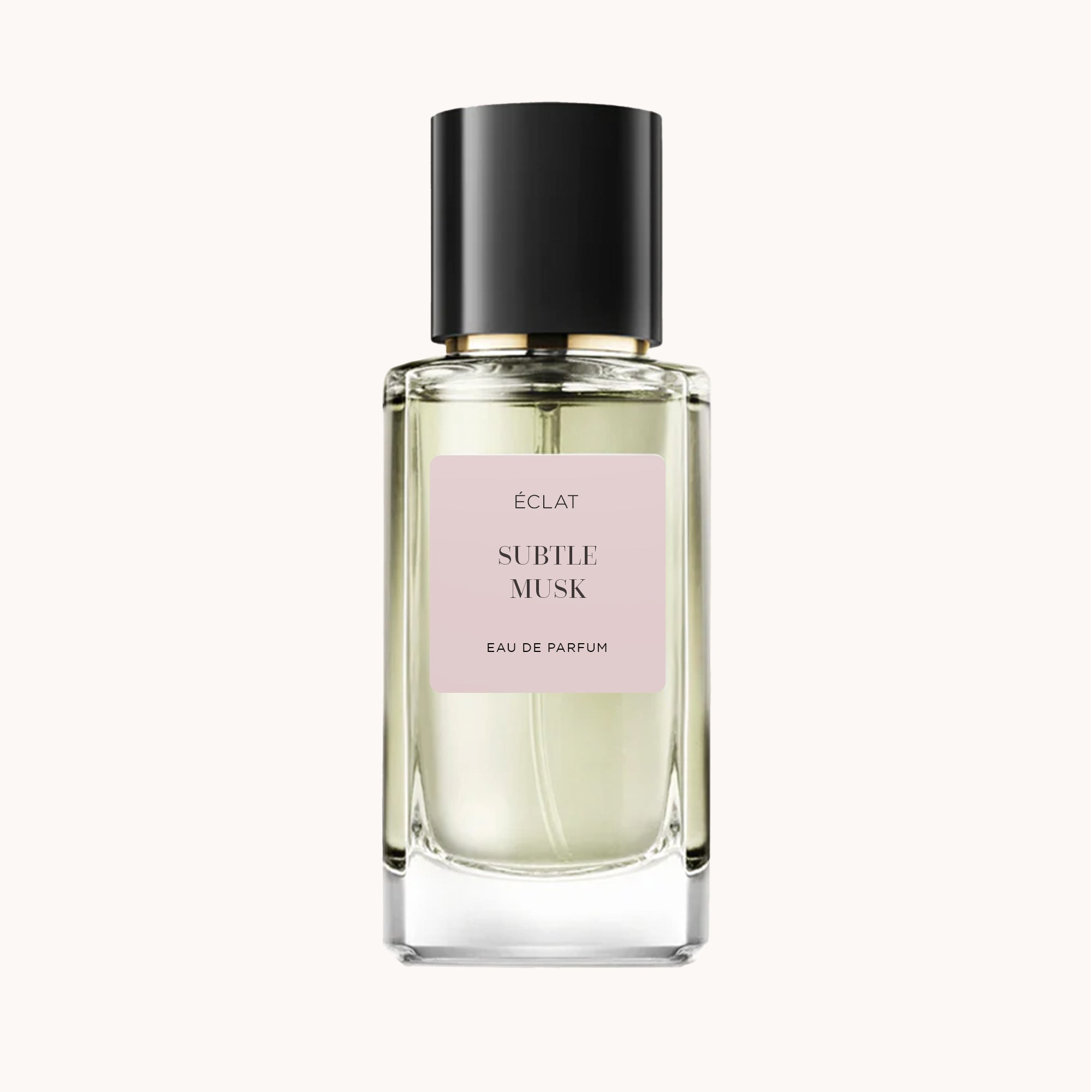 ÉCLAT Subtle Musk w przezroczystej, fasetowanej szklanej butelce z czarną nakrętką i delikatną różową etykietą.