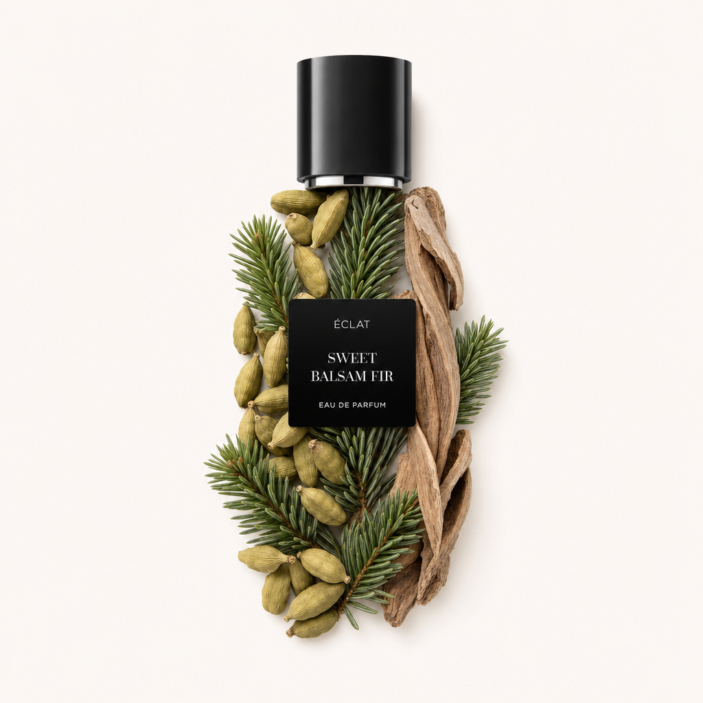 Kompozycja gałązek jodły balsamicznej, strąków kardamonu i wiórków drzewnych otacza czarną nakrętkę z etykietą ÉCLAT Sweet Balsam Fir.