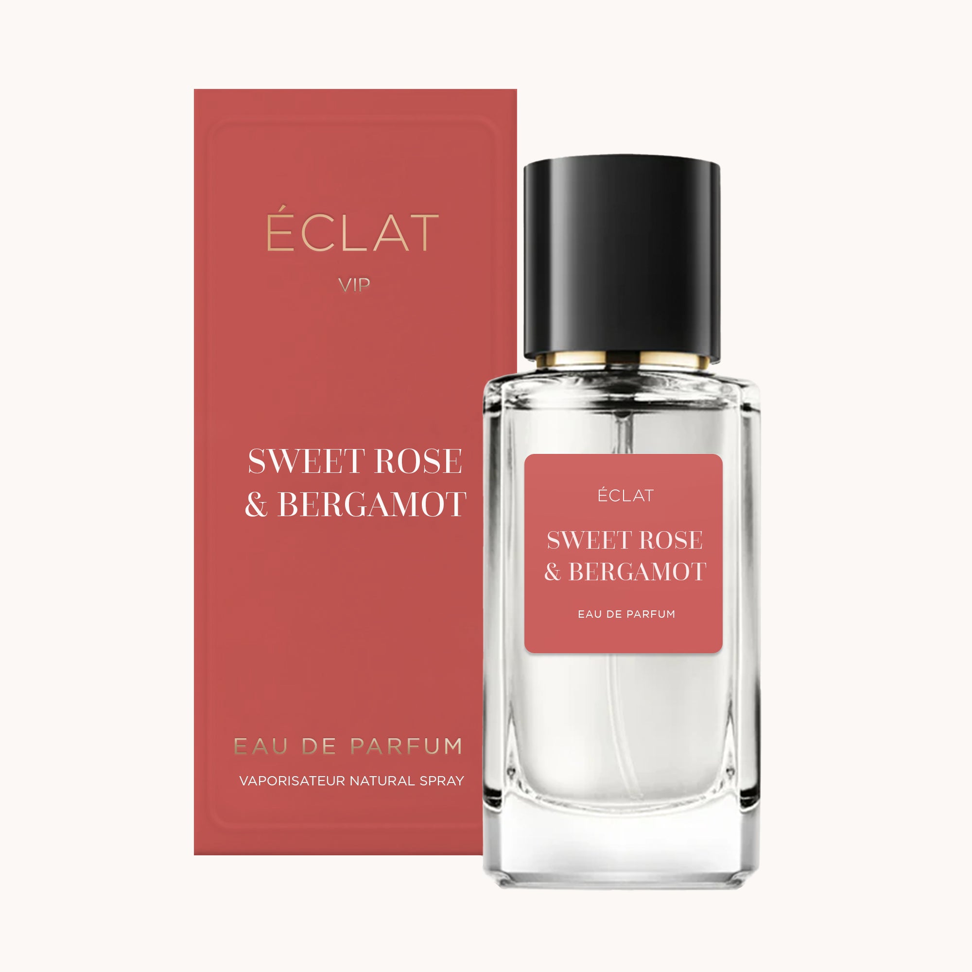 Fasetkowa butelka z ÉCLAT Sweet Rose & Bergamot z czarną zatyczką, obok dopasowanego różowego pudełka.