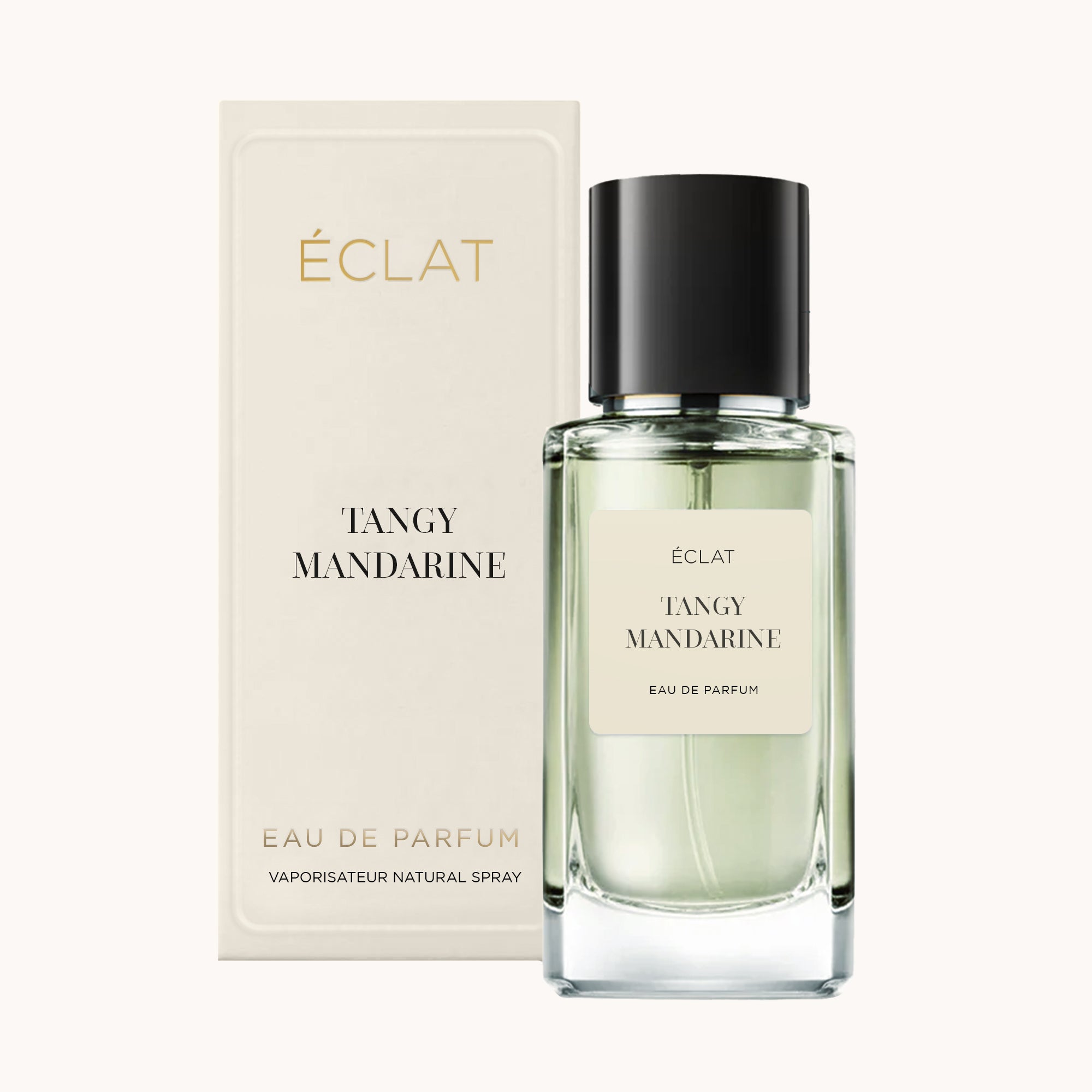 Fasetkowany szklany flakon ÉCLAT Tangy Mandarin z czarną nakrętką, obok eleganckiego kremowego pudełka.