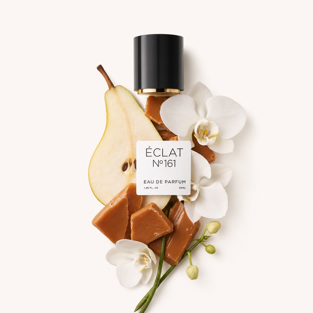 Kompozycja z kawałków toffi, plasterka gruszki i białych kwiatów orchidei została elegancko ułożona obok czarnej nasadki z etykietą z napisem ÉCLAT Toffee & Patchouli.
