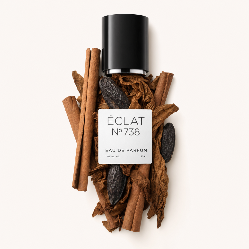 Czarna nakrętka z etykietą ÉCLAT Tonka Bean & Cinnamon umieszczona na kompozycji z lasek cynamonu i tonkowej fasoli.