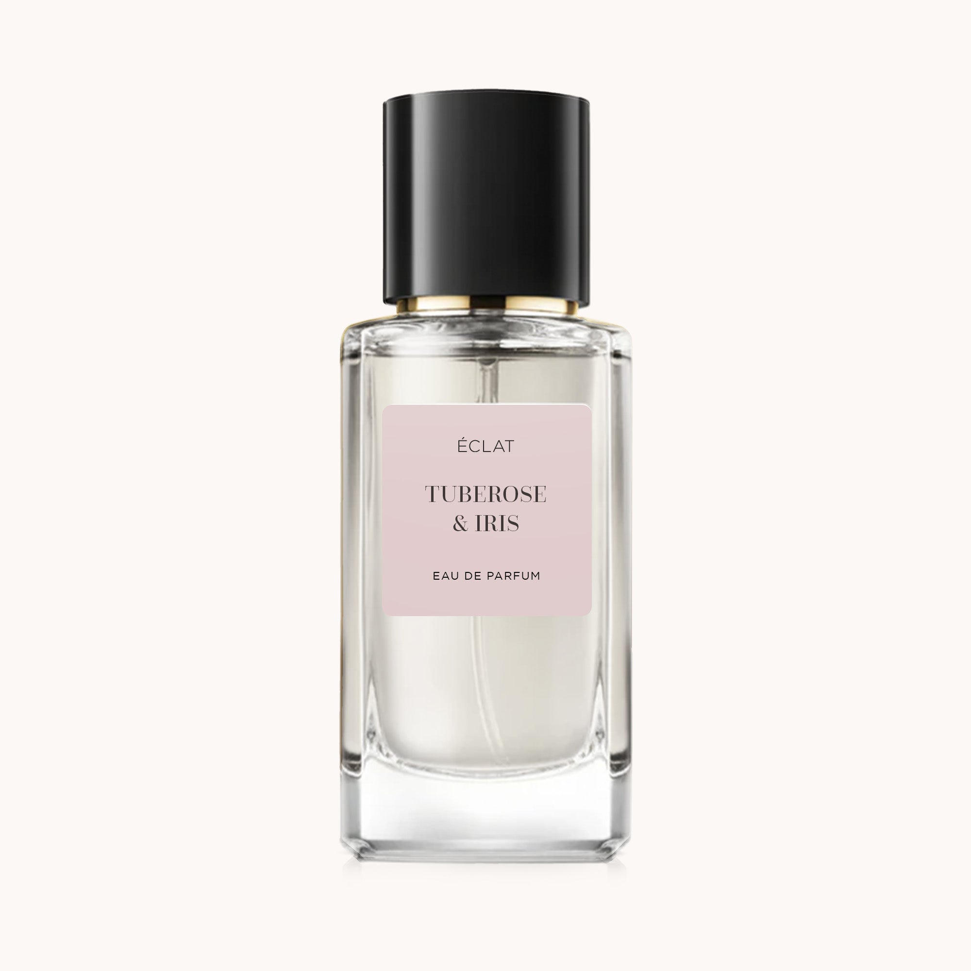 ÉCLAT Tuberose & Iris w szklanym flakonie o fasetowanej powierzchni z czarną nakrętką i delikatnoróżową etykietą.