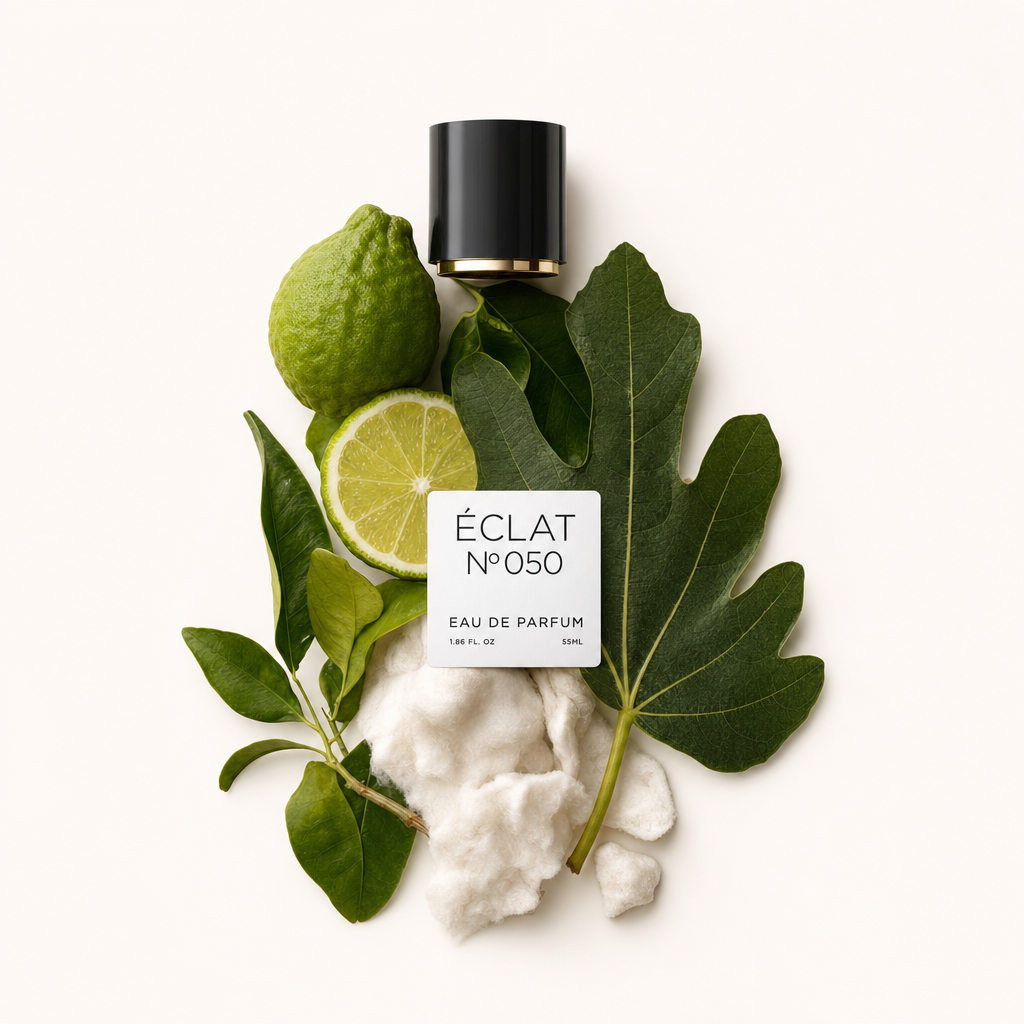 Kompozycja z owoców cytrusowych, zielonych liści i miękkich białych włókien, z czarną nakrętką z etykietą ÉCLAT White Musk & Citrus Fruits.