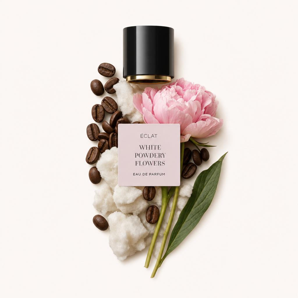 Aranżacja z waty, ziaren kawy i różowej piwonii obok czarnej nakrętki z etykietą ÉCLAT White Powdery Flowers.
