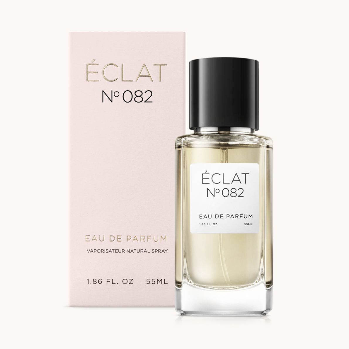 Butelka perfum ÉCLAT Woody Lemon z czarną nakrętką obok różowego pudełka ze złotymi literami.