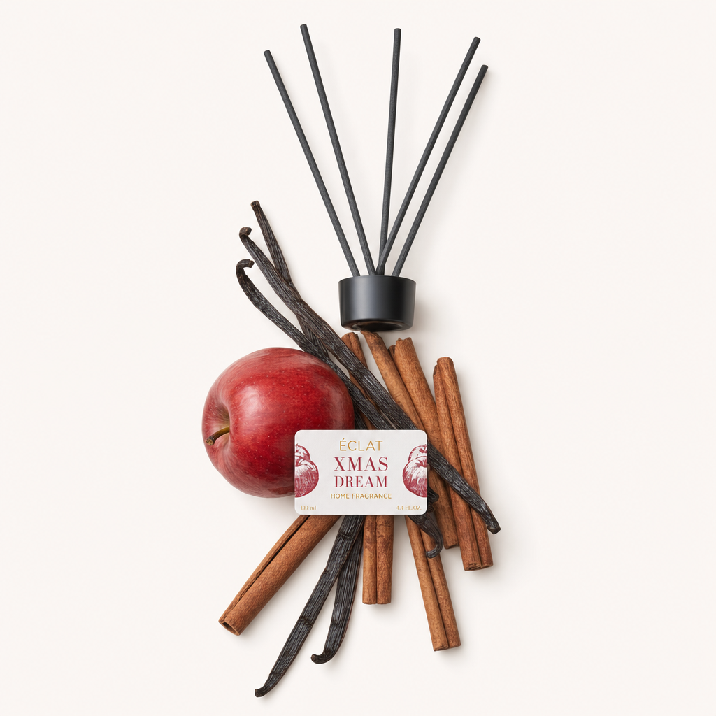 Kompozycja z czerwonego jabłka, lasek cynamonu i lasek wanilii dla ÉCLAT Xmas Dream Room Fragrance Sticks, obok oryginalnej czarnej nakrętki z etykietą.